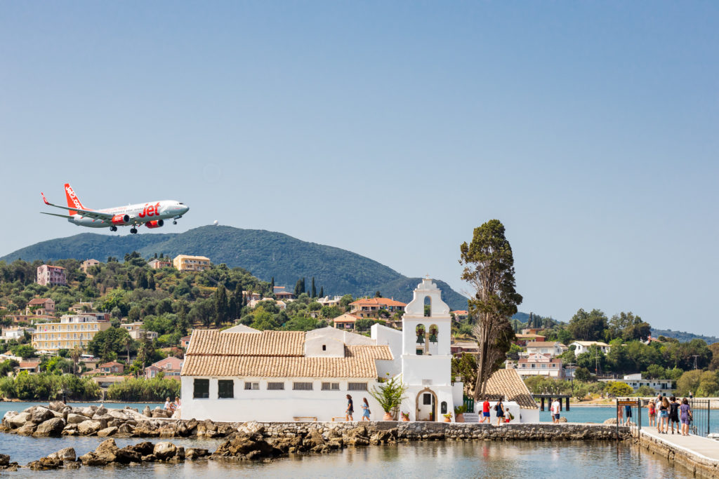 Corfu Greece Travel Guide: airplane flying over Vlacherna Monastery